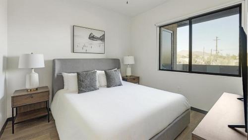 1 dormitorio con cama blanca y ventana en Landing - Modern Apartment with Amazing Amenities (ID9728X49), en Scottsdale