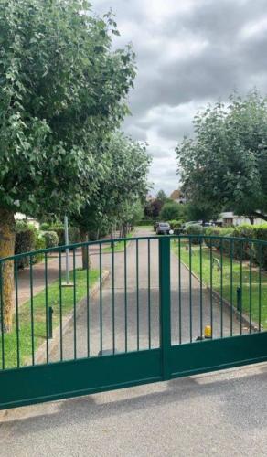 une porte verte avec une route derrière elle dans l'établissement Résidence Deauville 2000 à 50m plage, à Villers-sur-Mer