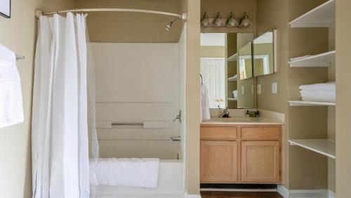 y baño con cortina de ducha y lavamanos. en Landing - Modern Apartment with Amazing Amenities (ID7932X45), en Holly Springs