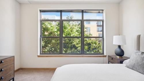 a bedroom with a bed and a large window at Landing - Modern Apartment with Amazing Amenities (ID9415X89) in Milwaukee