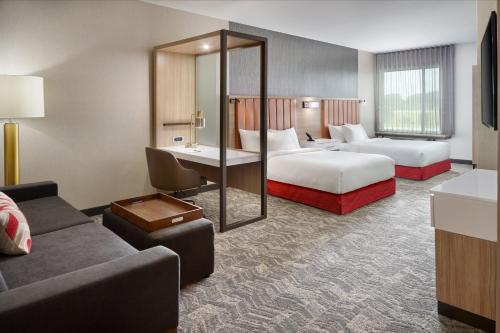 a hotel room with two beds and a couch at SpringHill Suites by Marriott Franklin Mint in Franklin