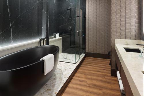 a bathroom with a black tub and a shower at SpringHill Suites by Marriott Franklin Mint in Franklin