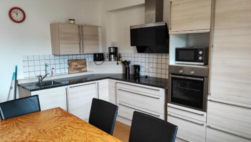 a kitchen with white cabinets and a table with chairs at Monteurwohnung bis zu 10 Personen mit 5 großen gratis Parkplätzen und WLAN in Veitshöchheim