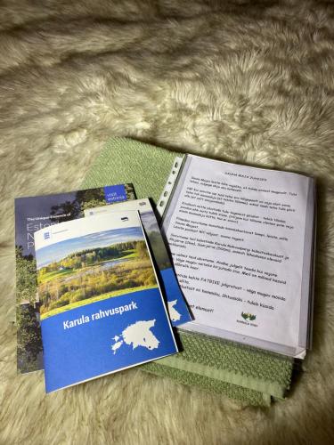 dos panfletos sentados encima de una cama en Karula Stay Sauna House in Karula National Park, en Ähijärve