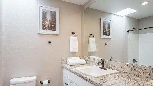 een badkamer met een wastafel, een toilet en een spiegel bij Landing - Modern Apartment with Amazing Amenities (ID8203X92) in Fremont