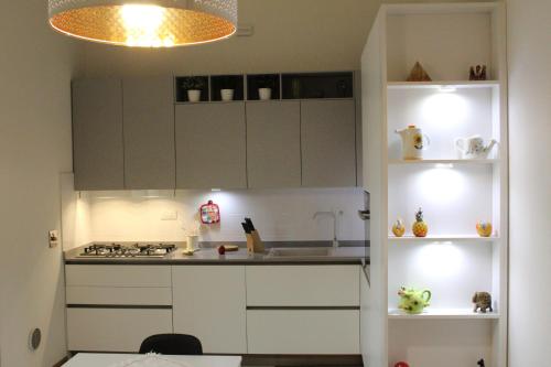 una pequeña cocina con armarios blancos y fregadero en appartamento cuore del chianti en Tavarnelle in Val di Pesa