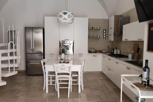 eine Küche mit einem Tisch und Stühlen sowie einem Kühlschrank in der Unterkunft Casa Mea in Grottaglie