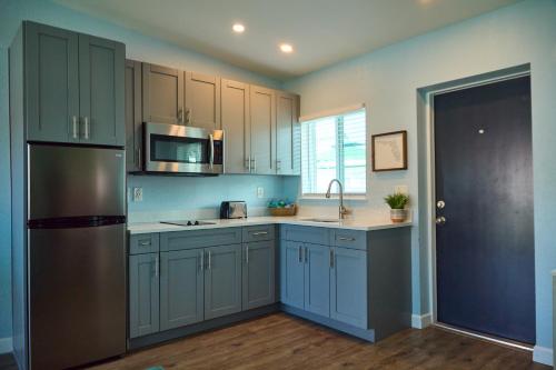a kitchen with blue cabinets and a stainless steel refrigerator at The Pearl Cabana Club in St Pete Beach