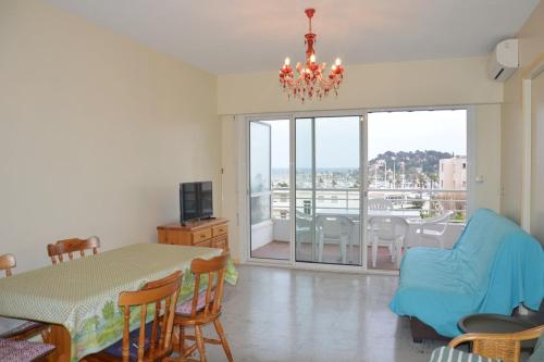 un salon avec une table à manger et un lustre dans l'établissement Appartement climatisé à 100m de la plage 122, à Cavalaire-sur-Mer
