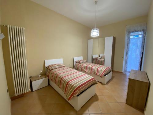 1 dormitorio con 2 camas y un espejo grande en Gravina House, en Portici