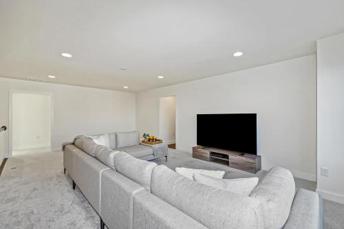 a living room with a couch and a flat screen tv at The Peninsula --- 24647 Navigators Walk in Millsboro