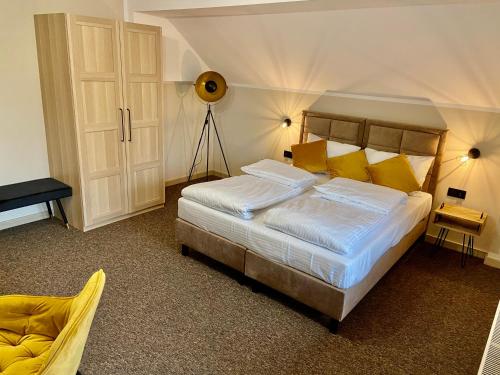 ein Schlafzimmer mit einem großen Bett mit gelben Kissen in der Unterkunft Villa Marta in Polanica-Zdrój