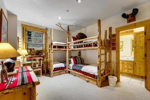 sypialnia z 4 łóżkami piętrowymi i biurkiem w obiekcie 3137 Arrowhead w mieście Teton Village