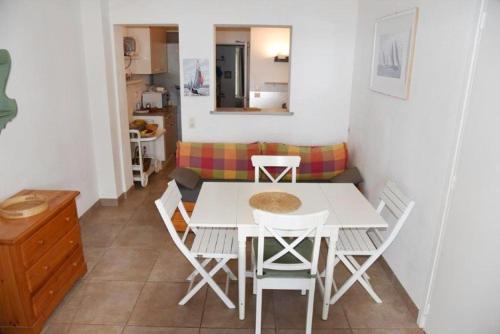 une salle à manger avec une table et des chaises blanches dans l'établissement Bel appartement 5 pers plage de Gigaro, à La Croix-Valmer