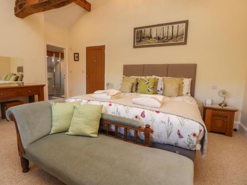 a bedroom with a large bed and a couch at Hill Brook Barn in Clitheroe
