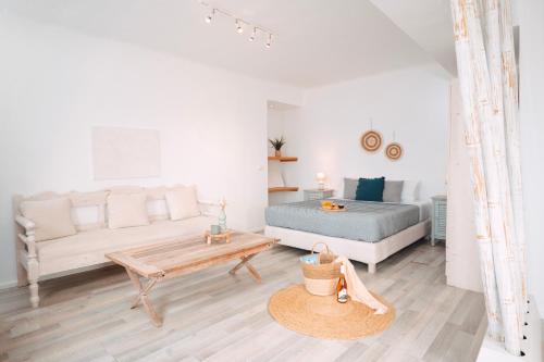 a white living room with a bed and a couch at With-inn Mykonos Suites in Tourlos