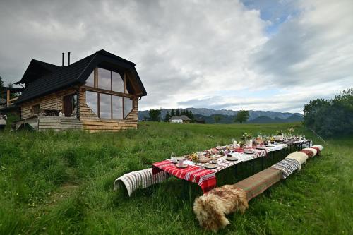 una mesa larga en un campo junto a una cabaña en The Barn, en Şirnea