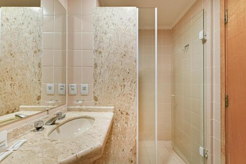 a bathroom with a sink and a shower at Hotel Golden Park Campinas Viracopos in Campinas