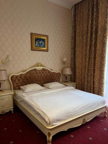 a bedroom with a large white bed with two tables at Oreanda Hotel in Odesa
