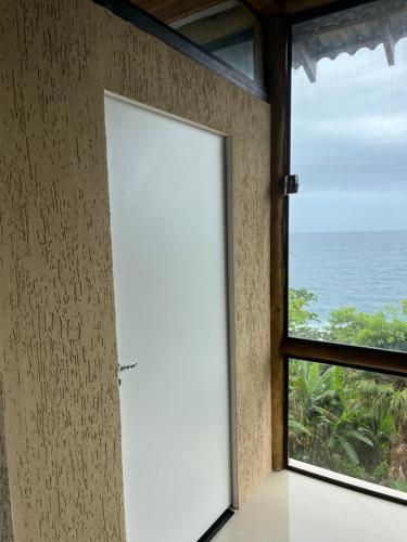 an open door in a room with a view of the ocean at CASA DE TUCA in Ilhabela