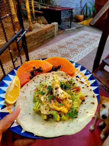 a person holding a plate of food on a table at Buena Onda Backpackers in San Juan del Sur