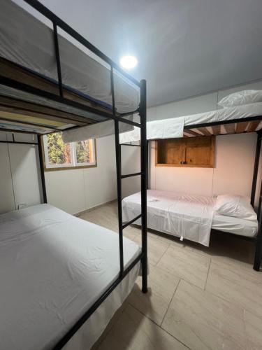 a room with three bunk beds in it at Rockxy HOSTEL BY JR in Providencia