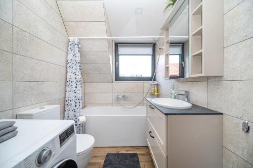 a bathroom with a sink and a tub and a toilet at Cozy Central Attic SELF Check In in Vilnius