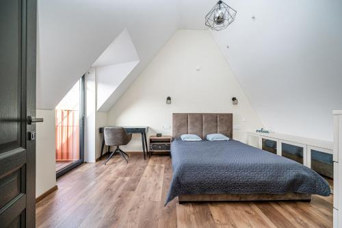 Dormitorio en el ático con cama y escritorio en Cozy Central Attic SELF Check In en Vilna