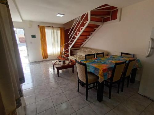 une salle à manger avec une table, des chaises et un escalier dans l'établissement Lo de fernando 1, à Río Gallegos
