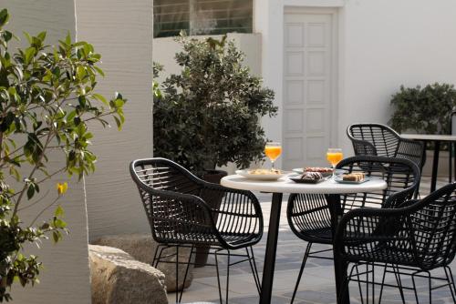a table with chairs and drinks on a patio at Iria Beach Art Hotel in Agia Anna Naxos
