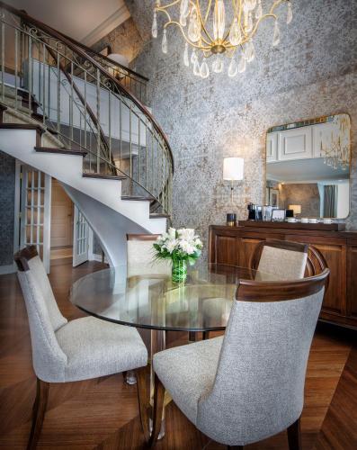 a dining room with a glass table and a staircase at Chateau Vaudreuil in Vaudreuil-Dorion