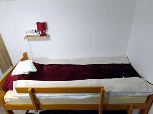Bett in einem Zimmer mit einer weißen Wand in der Unterkunft Java apartments - S & J in Dobrota