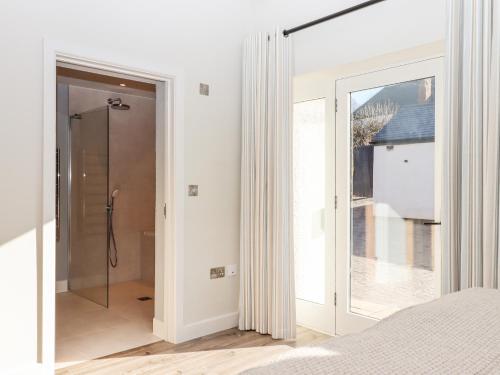 a bedroom with a glass door leading to a balcony at Lower Marsh Barns in Exeter