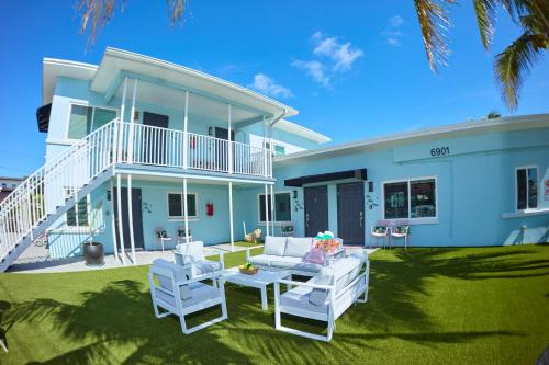 a blue house with two white chairs and a patio at The Pearl Cabana Club in St Pete Beach