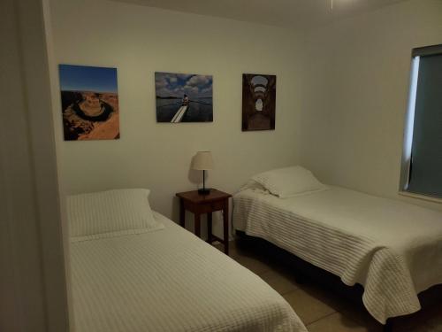 two beds in a room with pictures on the wall at Cozy family home in quiet area, nice garden views. in Tamiami
