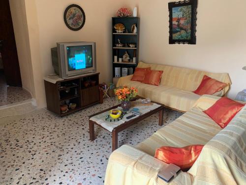 a living room with two couches and a tv at Family house near the sea in Kokkala