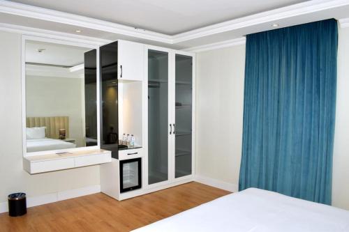 a bedroom with a bed and a bathroom with a mirror at فندق السلطنة جازان -Alsltanah Jazan Hotel in Jazan