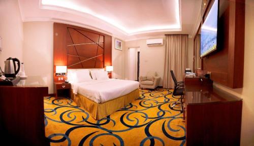 a hotel room with a bed and a flat screen tv at فندق السلطنة جازان -Alsltanah Jazan Hotel in Jazan