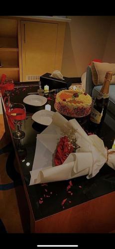 a table with a cake and a bottle of wine at فندق السلطنة جازان -Alsltanah Jazan Hotel in Jazan