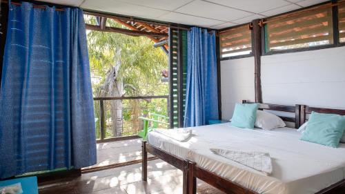 um quarto com uma cama e uma grande janela em Playa Hermosa Eco Resort em San Juan del Sur