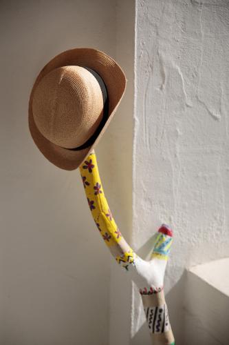 a hat is hanging on a wall next to a figurine at Iria Beach Art Hotel in Agia Anna Naxos