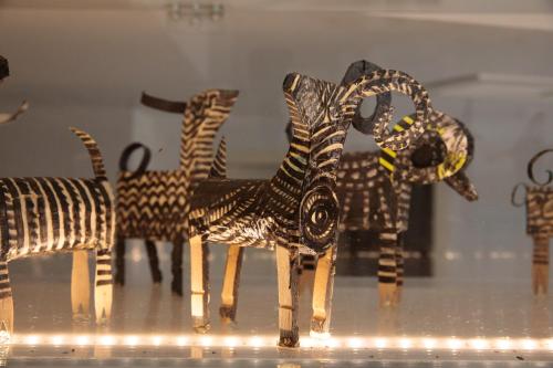 a group of wooden figurines in a display case at Iria Beach Art Hotel in Agia Anna Naxos