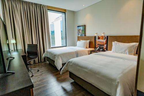 Habitación de hotel con 2 camas y ventana en Hampton By Hilton Santiago Las Condes, en Santiago