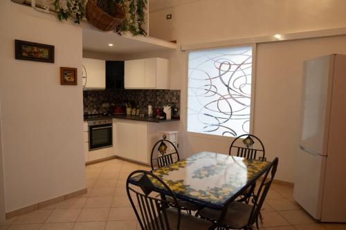 a kitchen with a table and chairs and a window at La solution 2023 in Vico Equense