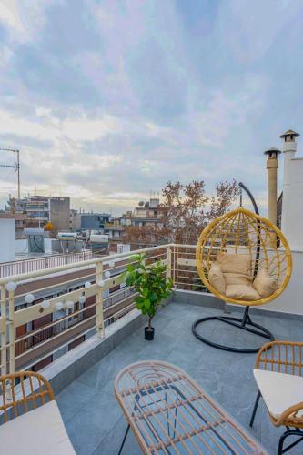 a patio with a rattan chair on a roof at Pomegranate Luxury Penthouse Maisonette with Stunning Terrace #Free Parking# by BiNoBi! in Thessaloniki