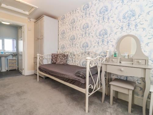 a bedroom with a bed and a vanity and a mirror at Molly's Bit in Chipping Norton
