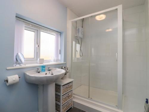 a white bathroom with a sink and a shower at Molly's Bit in Chipping Norton