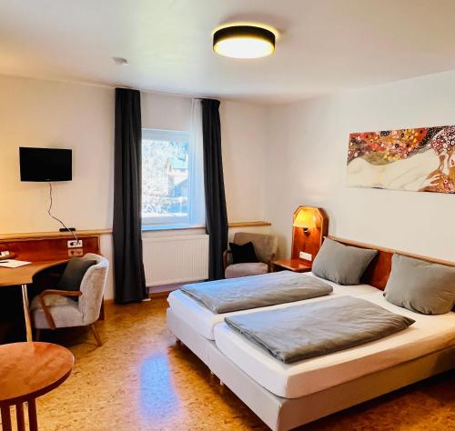 a hotel room with two beds and a desk at TheCrossing Bed & Breakfast in Hausen im Tal