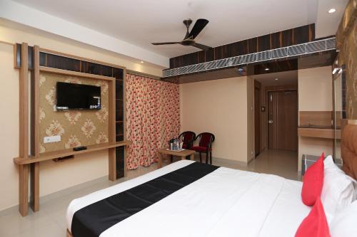 Habitación de hotel con cama y TV en Hotel Victoria Royal, en Puri