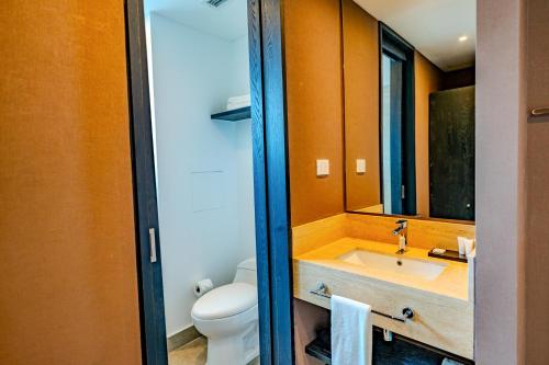 y baño con lavabo, aseo y espejo. en Hampton By Hilton Santiago Las Condes, en Santiago